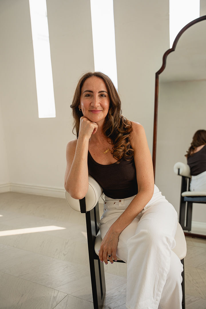 Emily seated, hand to chin